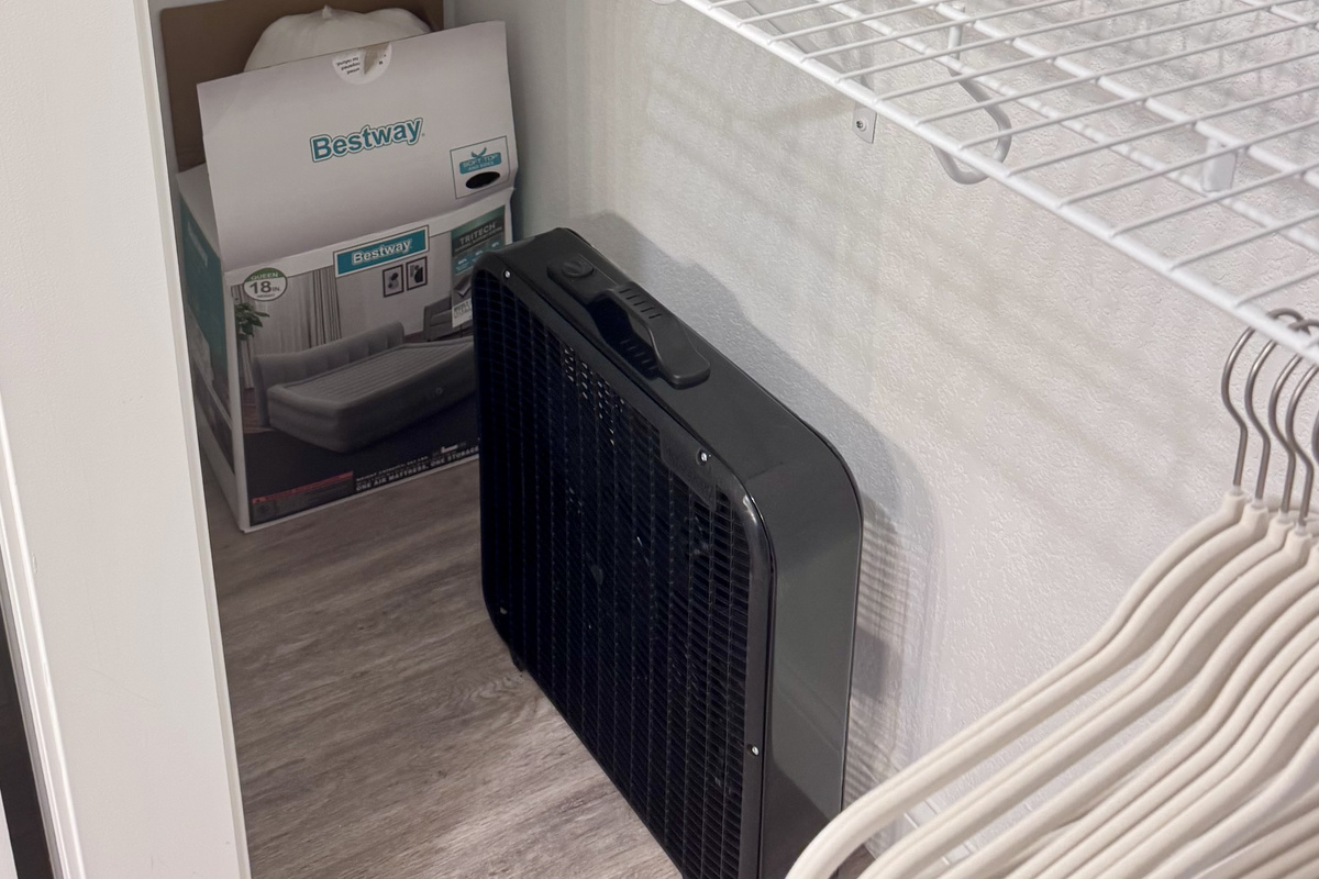 A queen self-inflating air mattress 18" tall with sheets, blanket, pillows, and box fan located in the Primary Bathroom