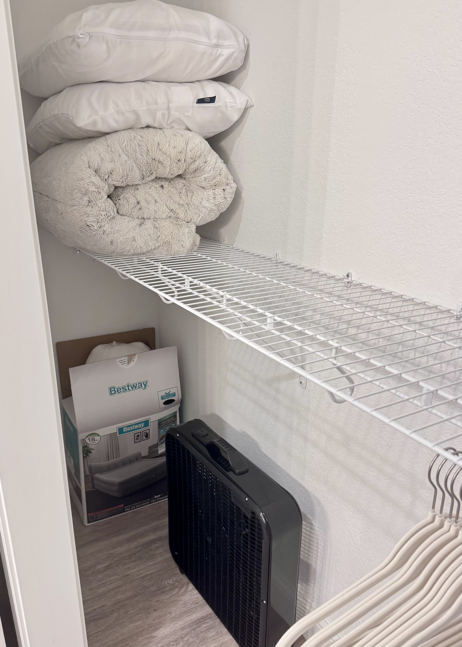 A queen self-inflating air mattress 18" tall with sheets, blanket, pillows, and box fan located in the Primary Bathroom