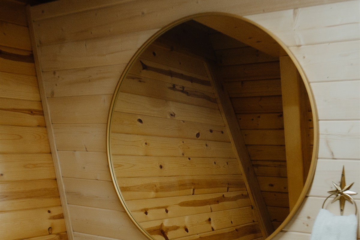 Moody half bath at Poppywood Pines featuring rustic wood accents, western-inspired decor, and warm ambient lighting. A cozy White Mountains AZ cabin detail designed for elevated guest comfort and boutique short-term rental charm. 🌲✨
