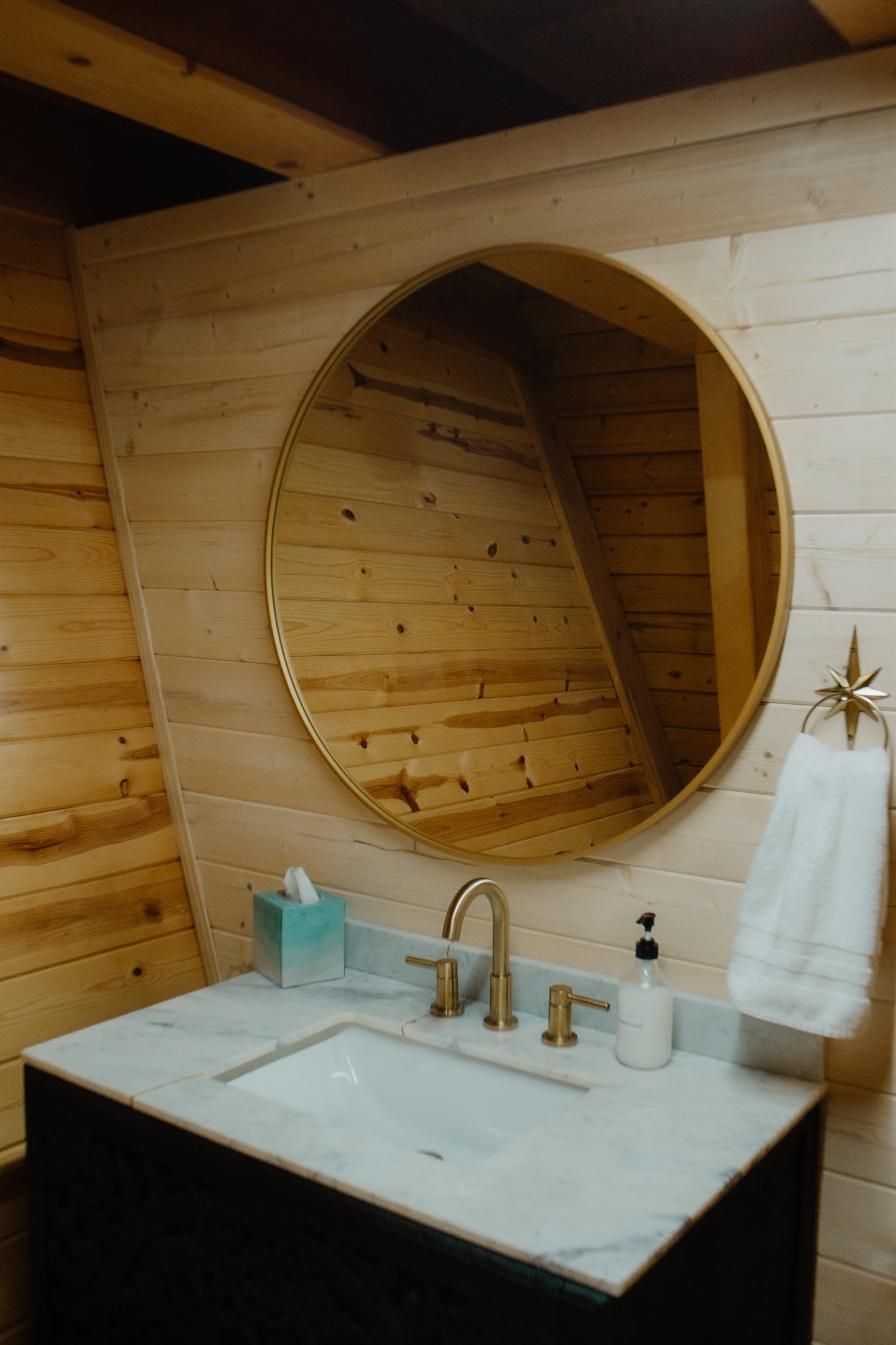Moody half bath at Poppywood Pines featuring rustic wood accents, western-inspired decor, and warm ambient lighting. A cozy White Mountains AZ cabin detail designed for elevated guest comfort and boutique short-term rental charm. 🌲✨