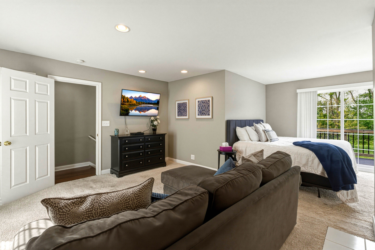 2nd floor master with jacuzzi tub and small living room with couch and balcony