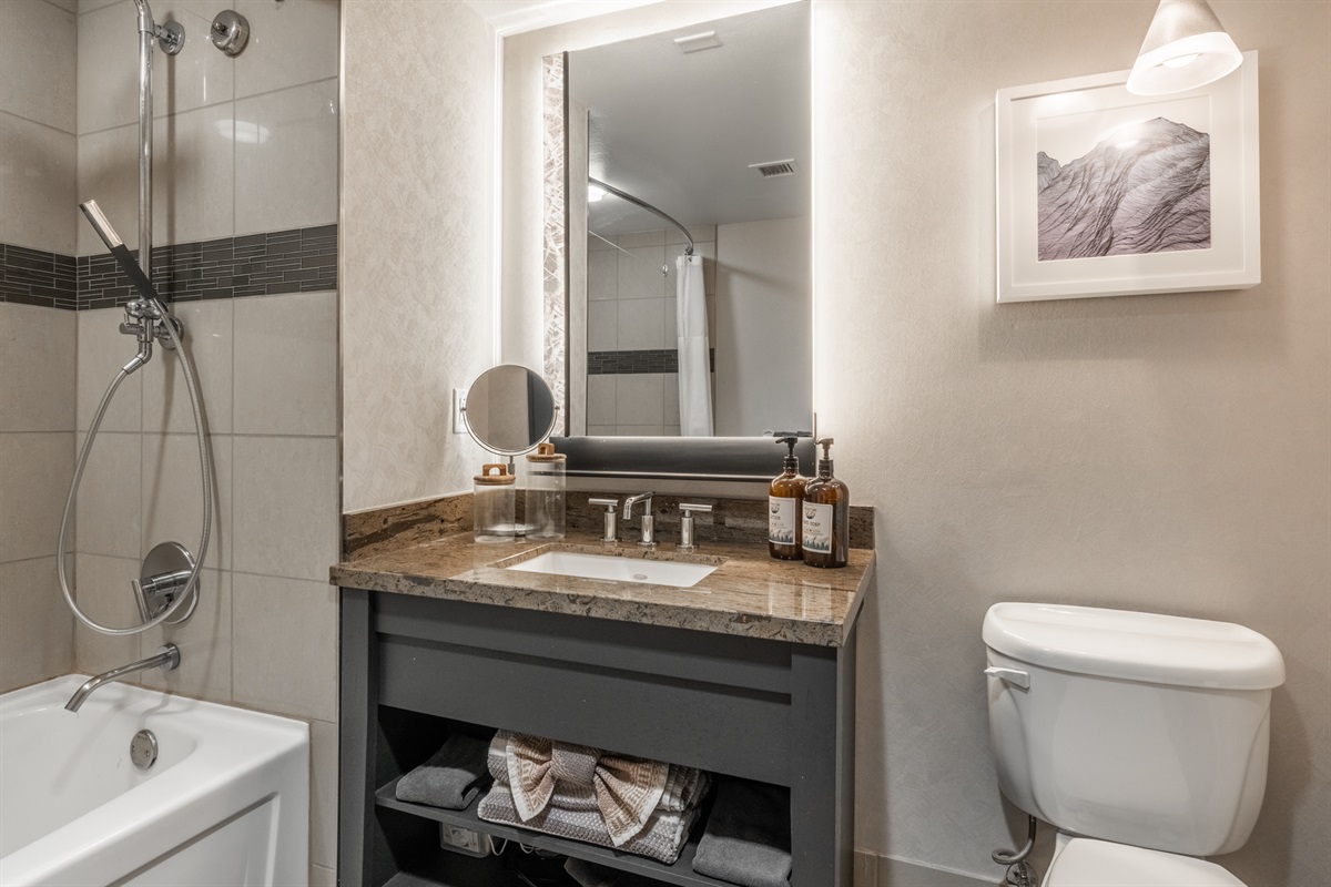 A sleek vanity and mirror anchor the space, offering bright lighting and a fresh, modern feel for getting ready.