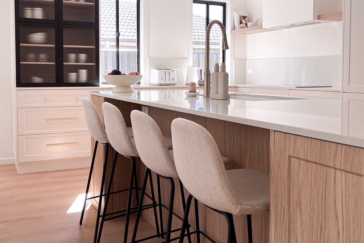 Bar stools at the kitchen island add casual seating beside the bench, sink and main kitchen workspace.