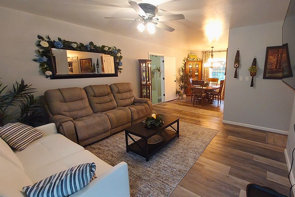 This cozy open living area features a coil-spring futon , a dual-powered sofa with adjustable headrests, leg rests, and built-in charging ports—all centered around a 55" TV for easy relaxation and the perfect spot to unwind after a long day.