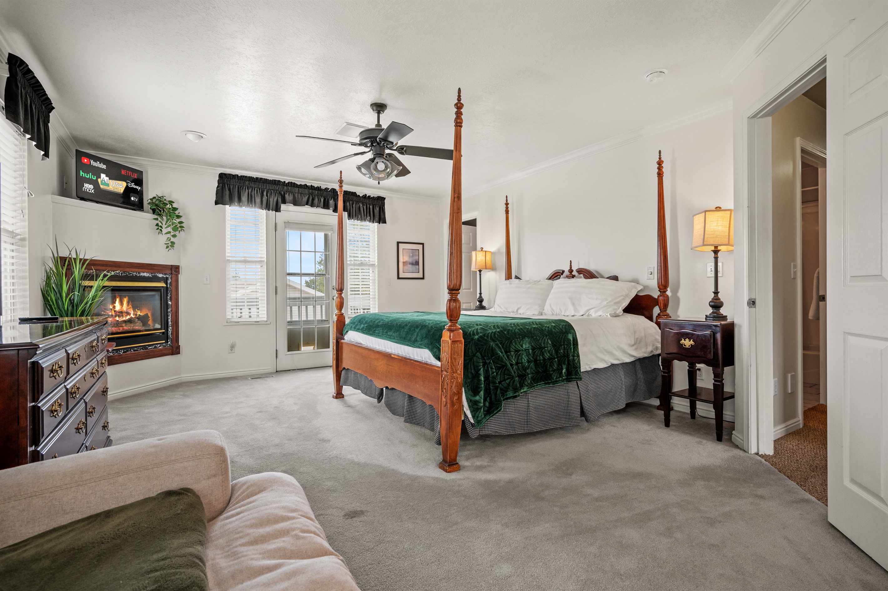 Spacious primary bedroom featuring a luxurious king bed, cozy seating area, and fireplace.