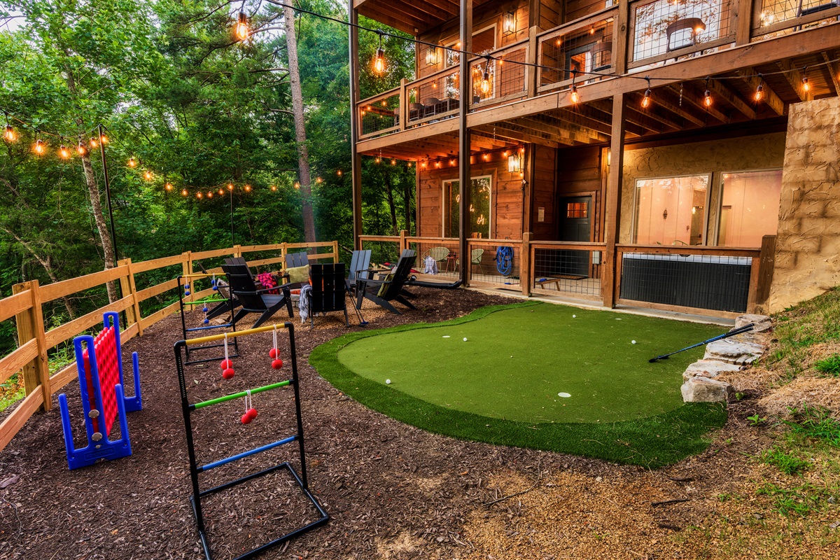 Backyard with fire pit, mini golf, string lights  and games