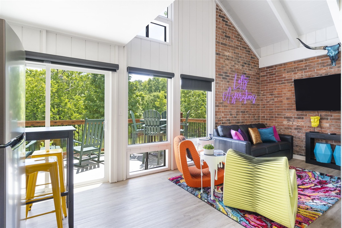 Open living and dining space with a walk-out porch overlooking a finger of Lake TaneyComo.