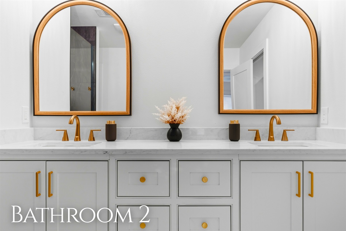Twin mirrors and a spacious vanity offer plenty of room for guests to get ready while keeping the space bright and functional.