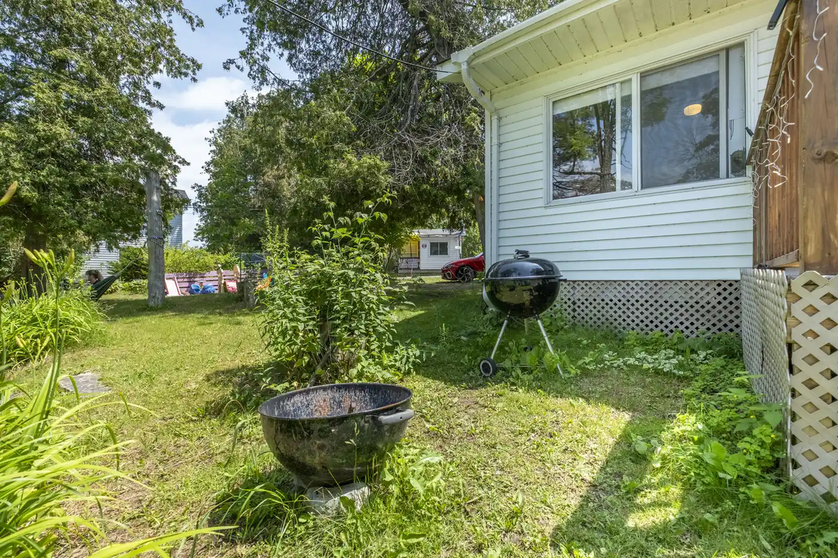 Side exterior of Cottage #1 with lawn and mature trees