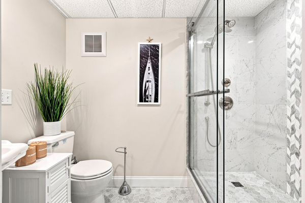 A convenient lower-level bathroom with a glass-enclosed shower makes getting ready easy for larger groups.
