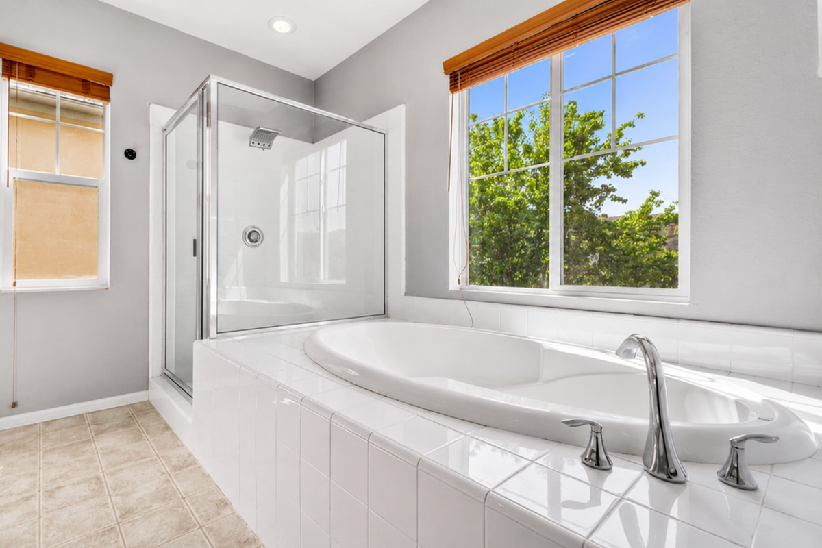 Bathroom with a soaking tub, glass shower, and sunny windows for a relaxing start or end to the day.