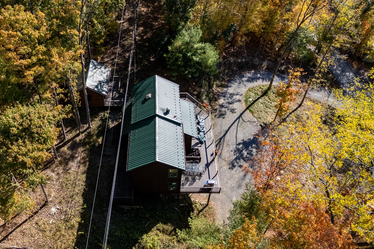 Top-down view of the cabin’s deck and firepit area amidst trees.