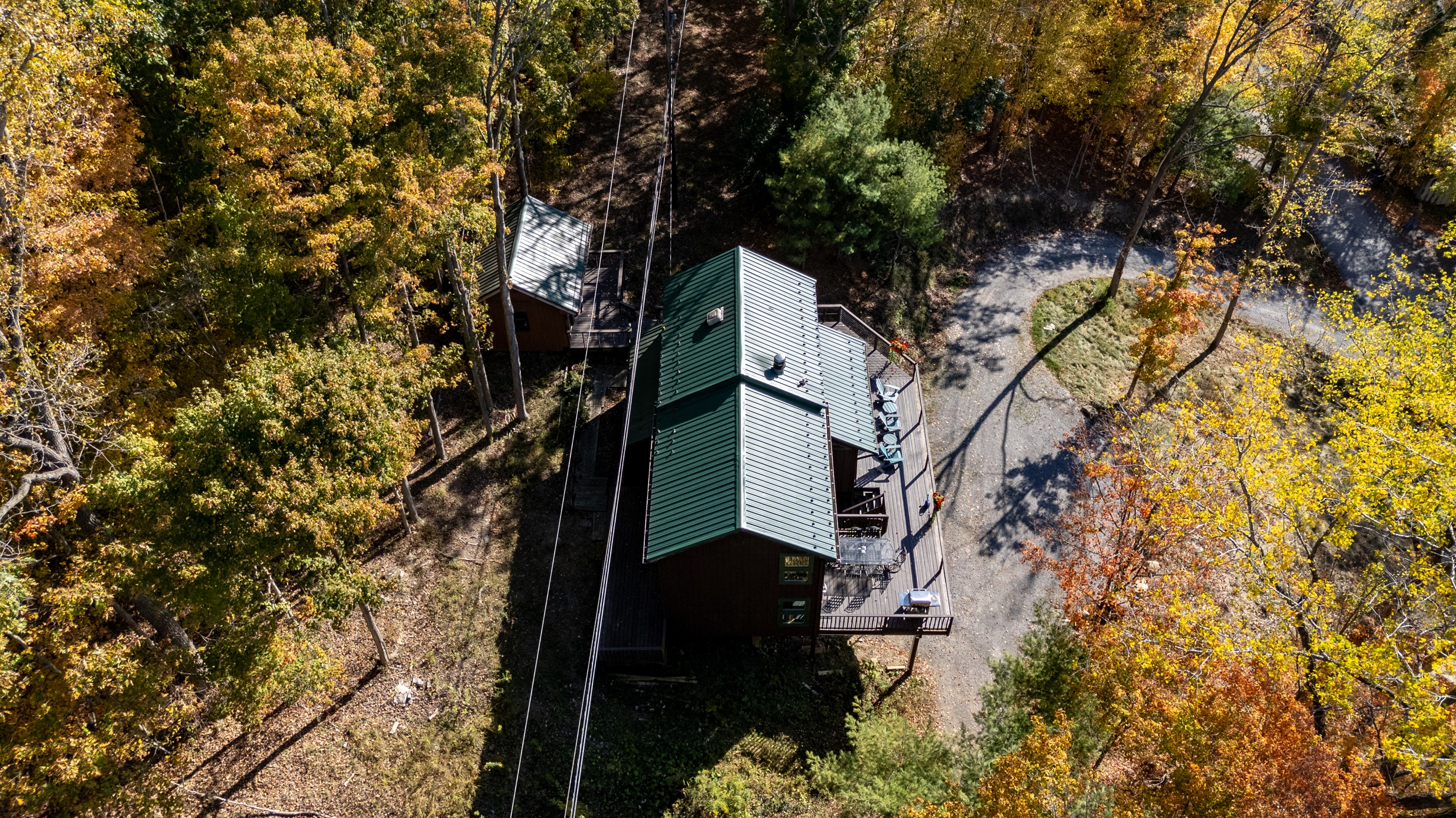 Top-down view of the cabin’s deck and firepit area amidst trees.