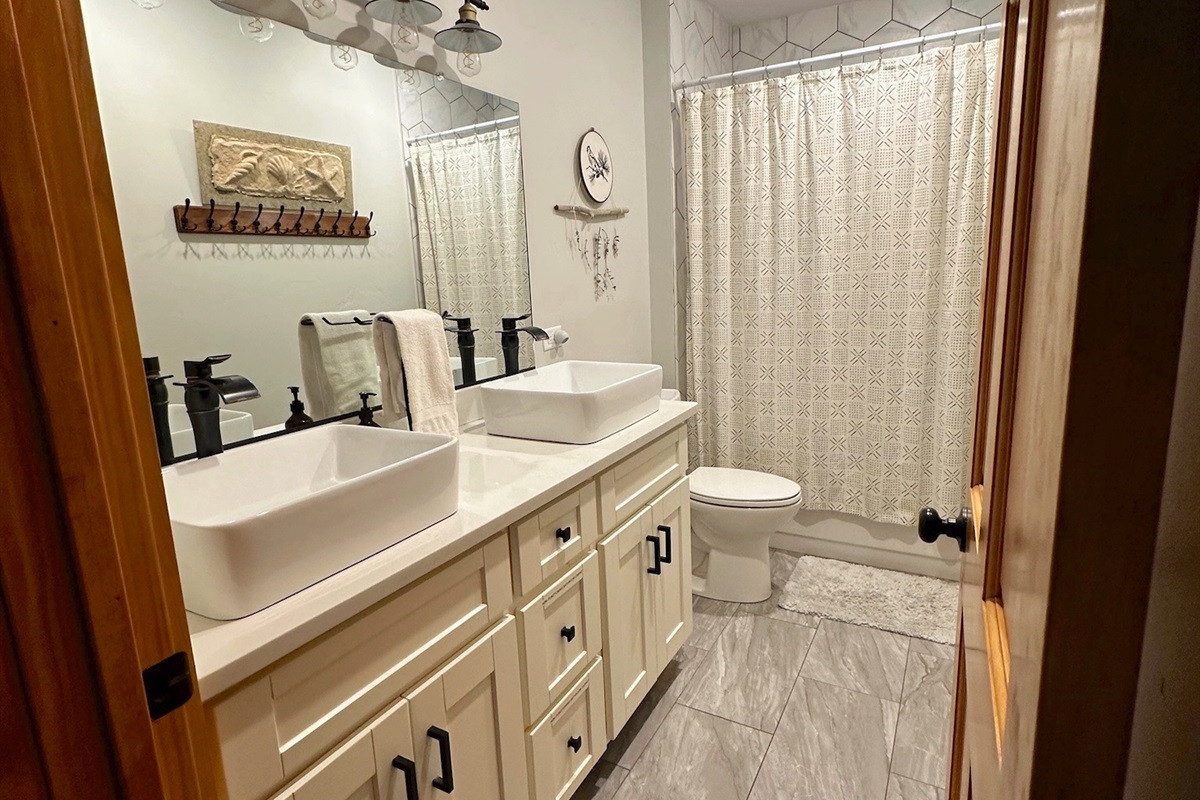 Charming bathroom #2 features double sinks and a shower/tub combo.