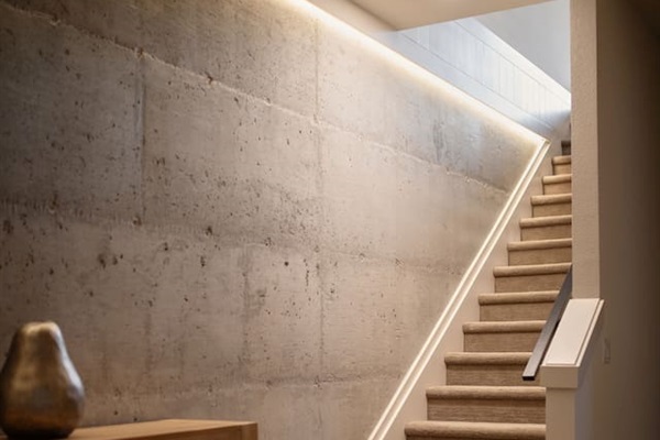 These are the stairs leading to the downstairs game room and three bedrooms. The concrete accent wall is one of our favorite features of the home.