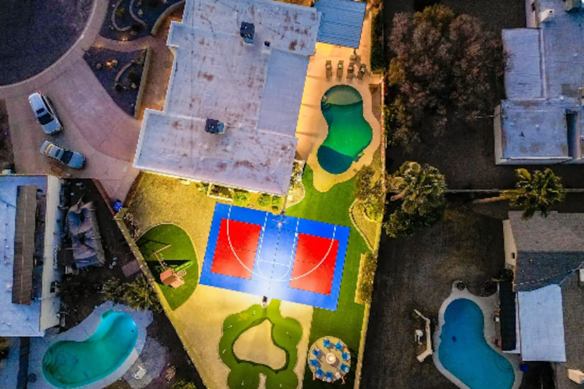 A backyard built for a crowd: pool, sport court, and putting green, all on one oversized lot.