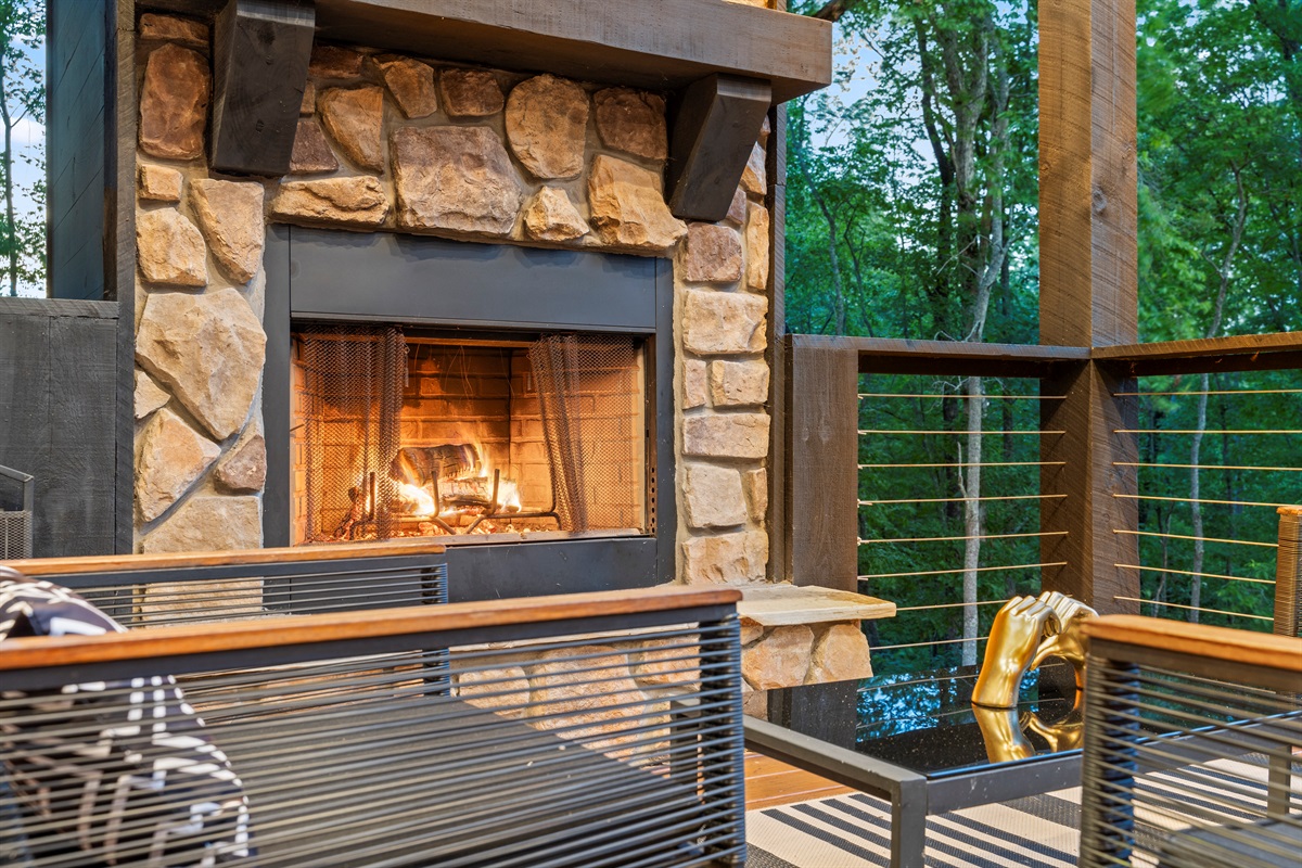 The stone fireplace anchors this outdoor seating area, providing a warm and inviting space to gather and relax.