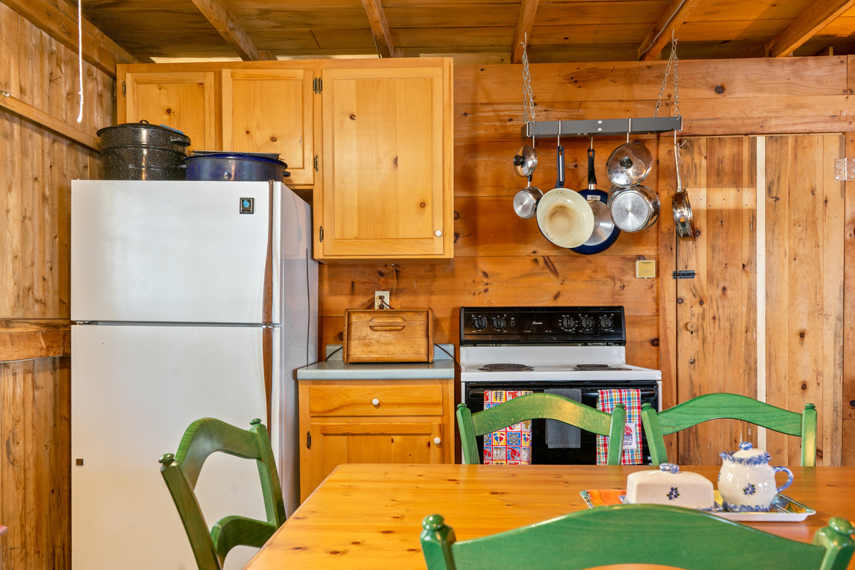 Fully equipped kitchen station at Loonrise Point! Features full-size refrigerator, electric stove, hanging pot rack, and large lobster pots. Everything you need for home-cooked meals on Beech Hill Pond in Otis, ME.