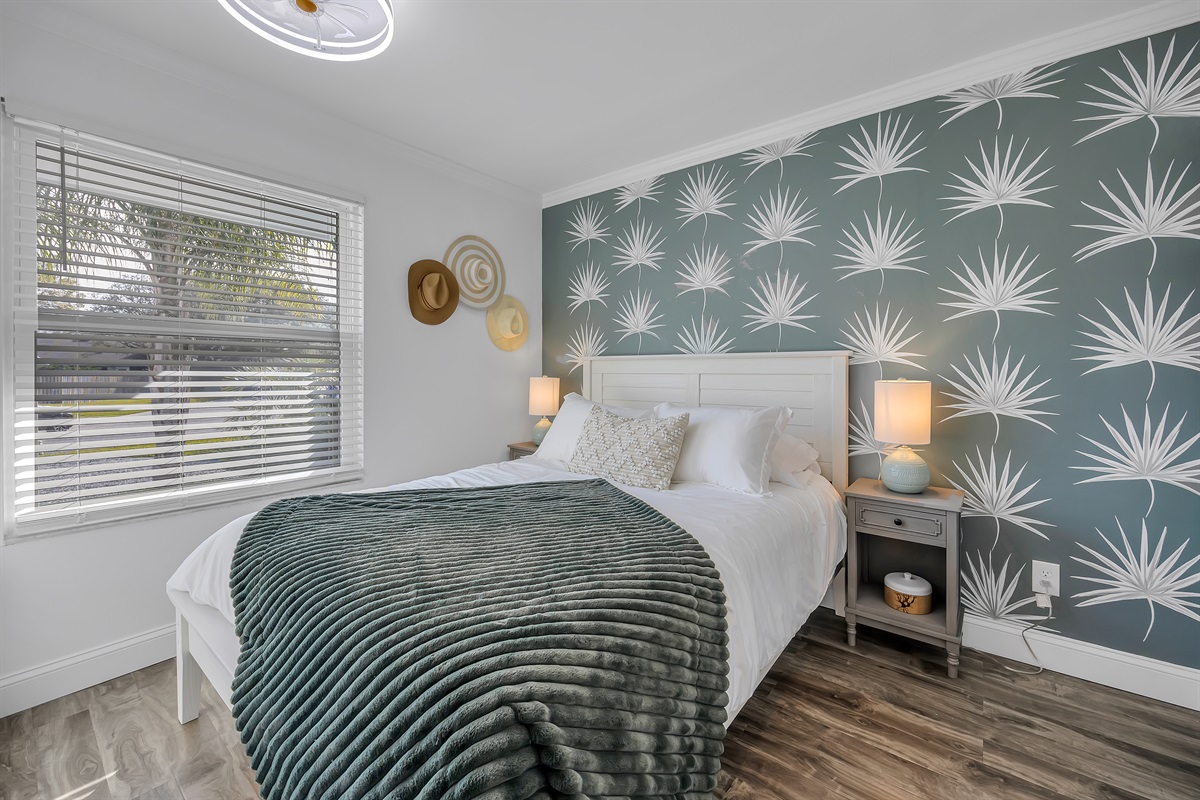 Queen bedroom with tropical accent wall 