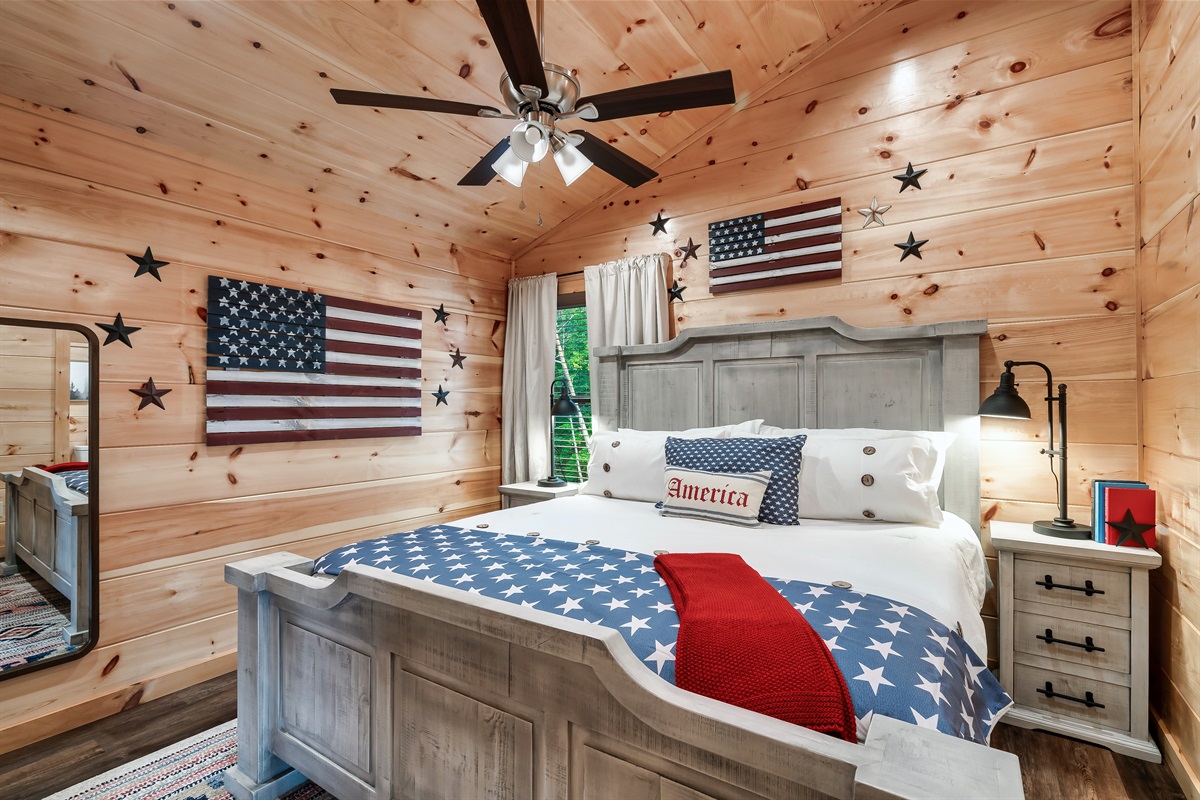 Americana themed bedroom with king bed, en-suite bathroom and 32 inch smart TV.