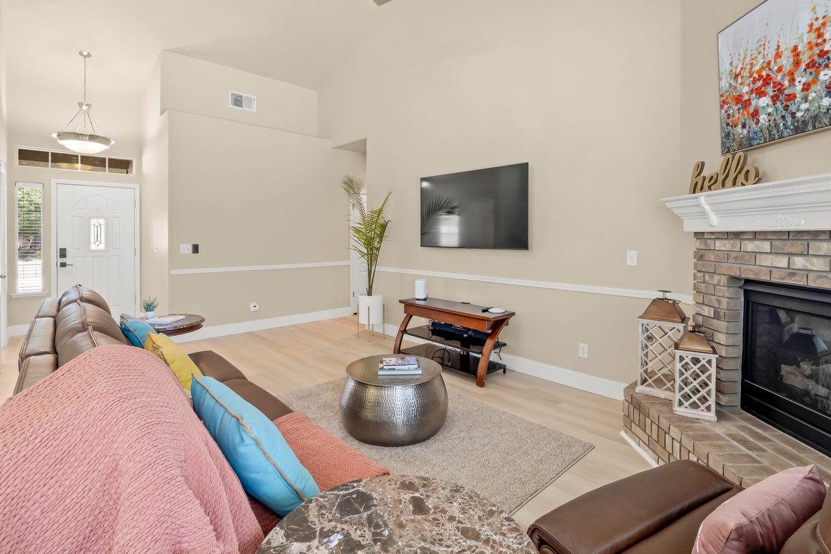 Settle in and relax in this comfortable living room featuring plush reclining seating, a cozy fireplace, and a large TV.