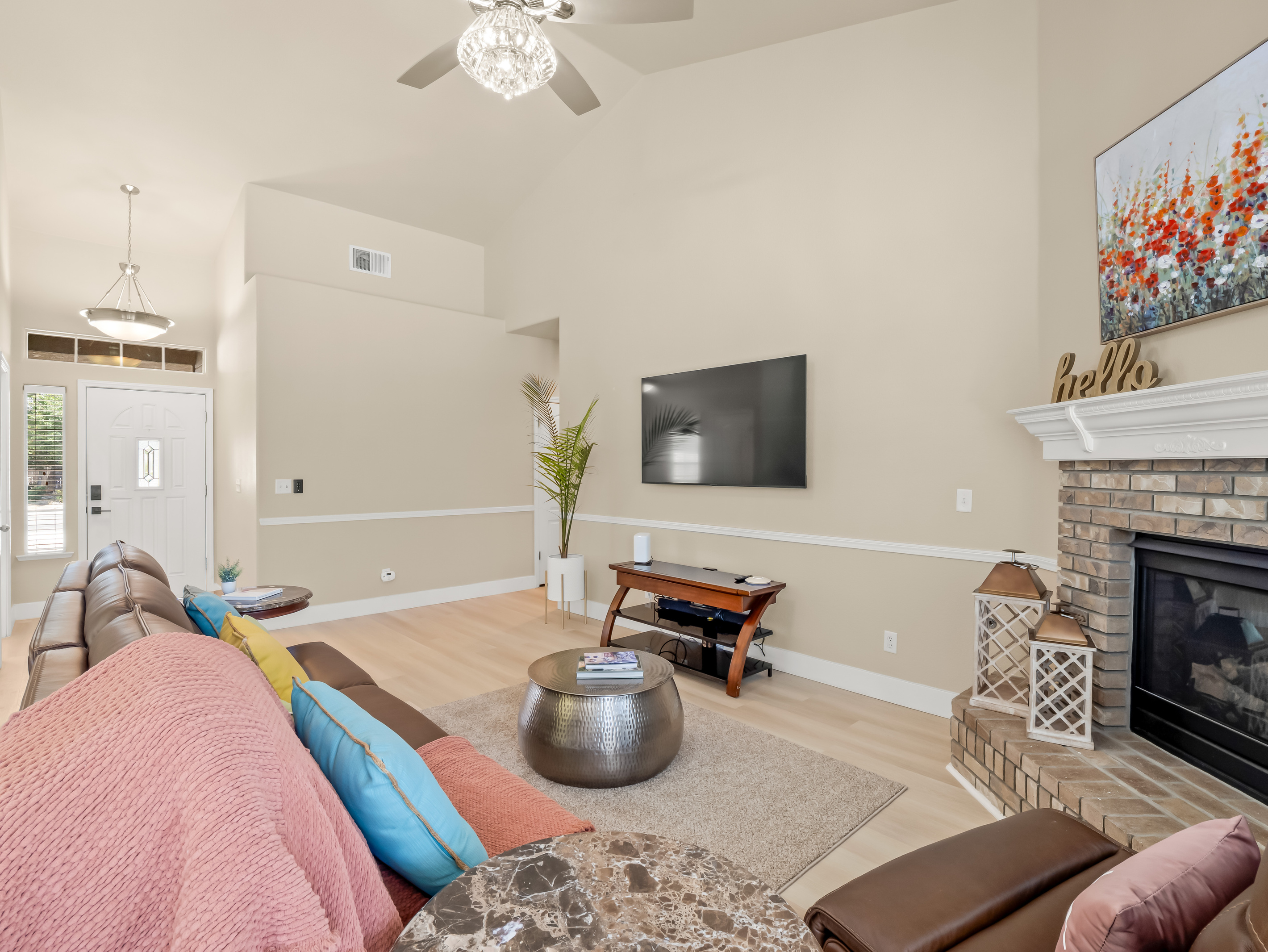 Settle in and relax in this comfortable living room featuring plush reclining seating, a cozy fireplace, and a large TV.