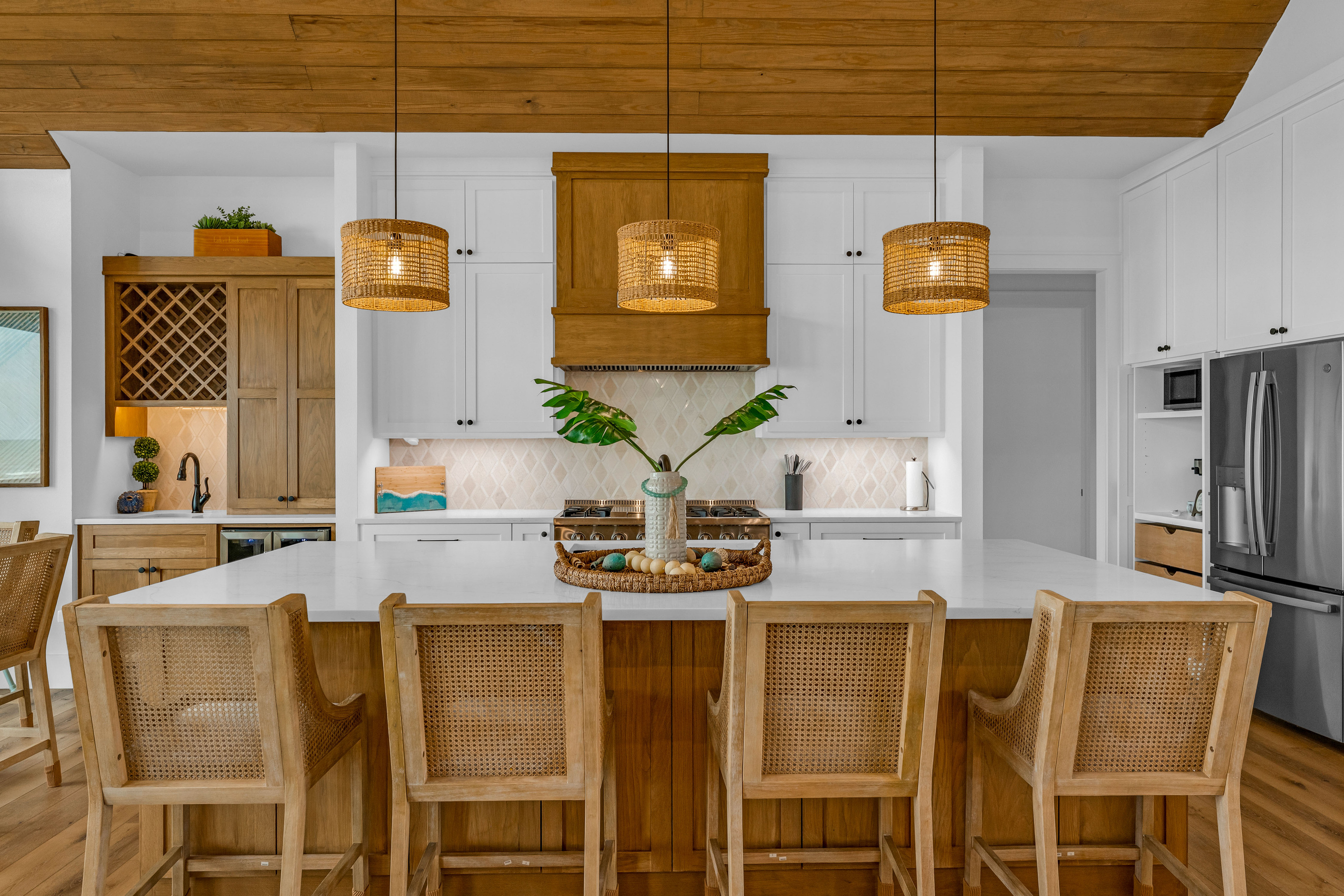 Cair Paravel: Wide quartz countertops, custom cabinetry, and a wall of windows framing the Gulf, this is a kitchen guests actually want to cook in.