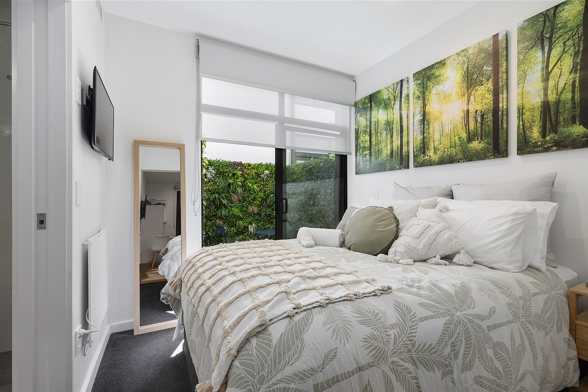 Cute comfy bedroom looking out to courtyard