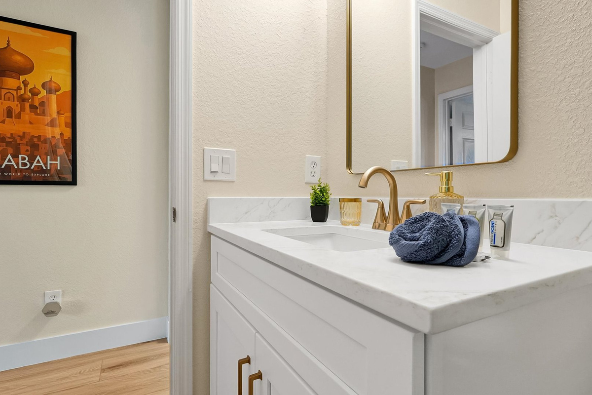 Aladdin King Suite Ensuite: Bright vanity with generous counter space, starter toiletries and Agrabah-inspired artwork.