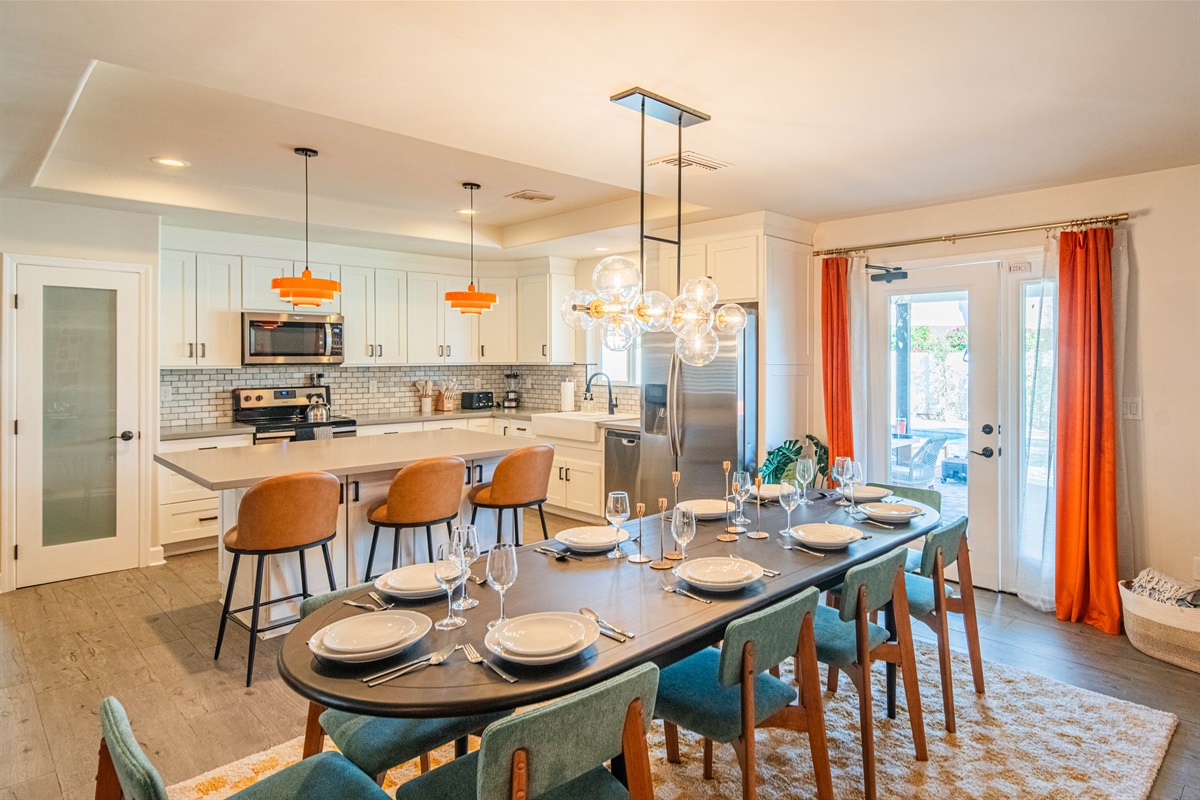 Large dining setup with place settings and direct patio access, creating a seamless indoor-outdoor flow for meals and entertaining.