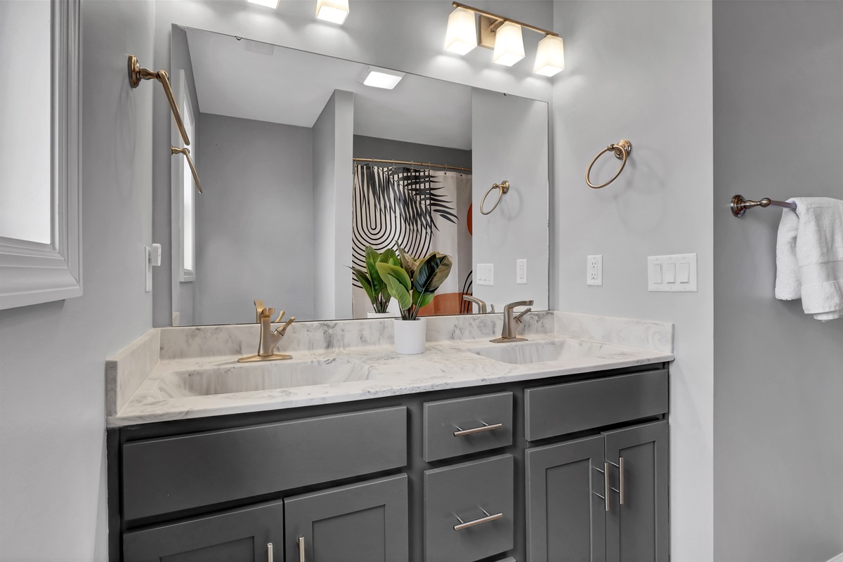 Full hall bathroom with double vanity and shower/tub combo - designed for easy use during your beach stay