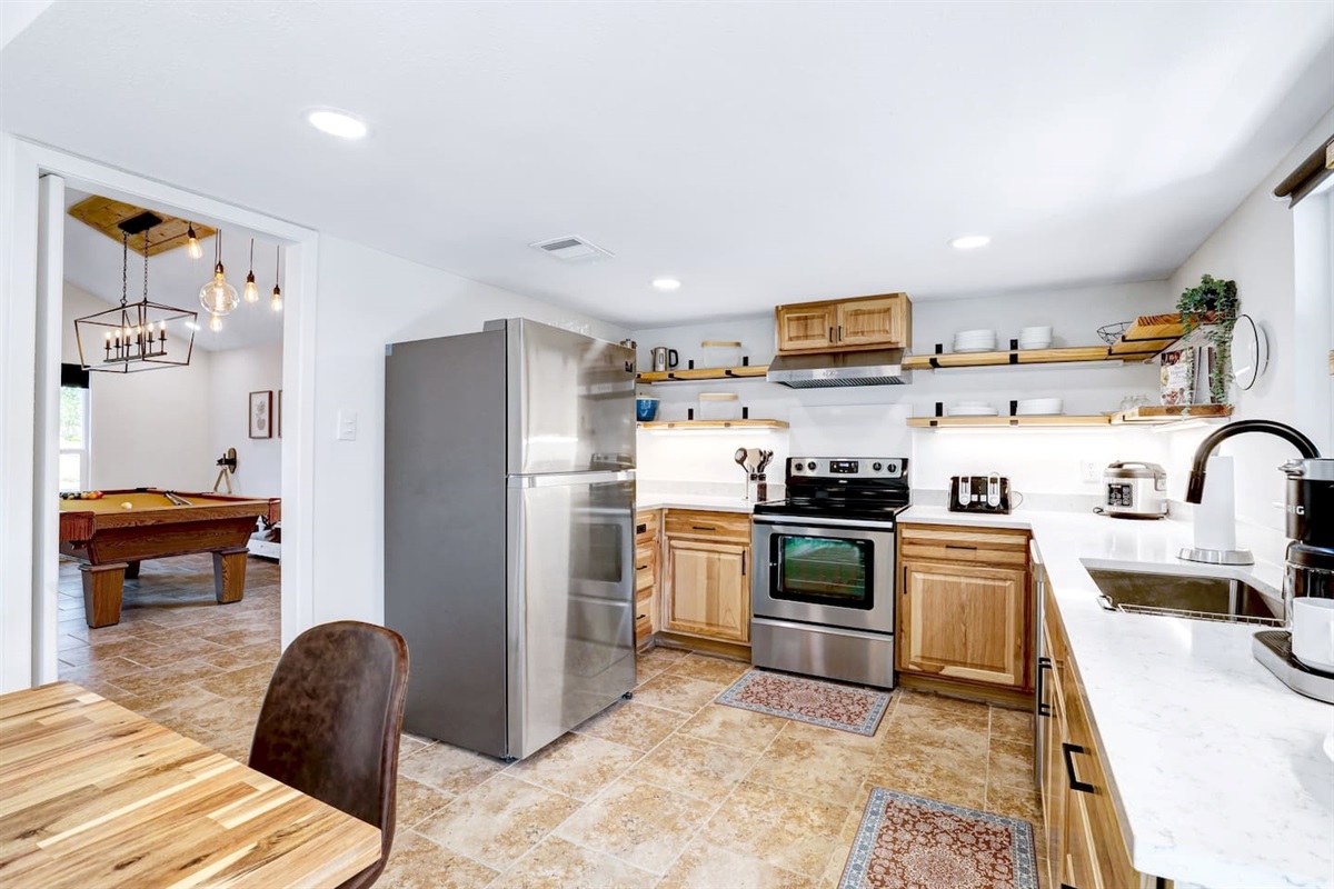 Kitchen with pool table room in the background