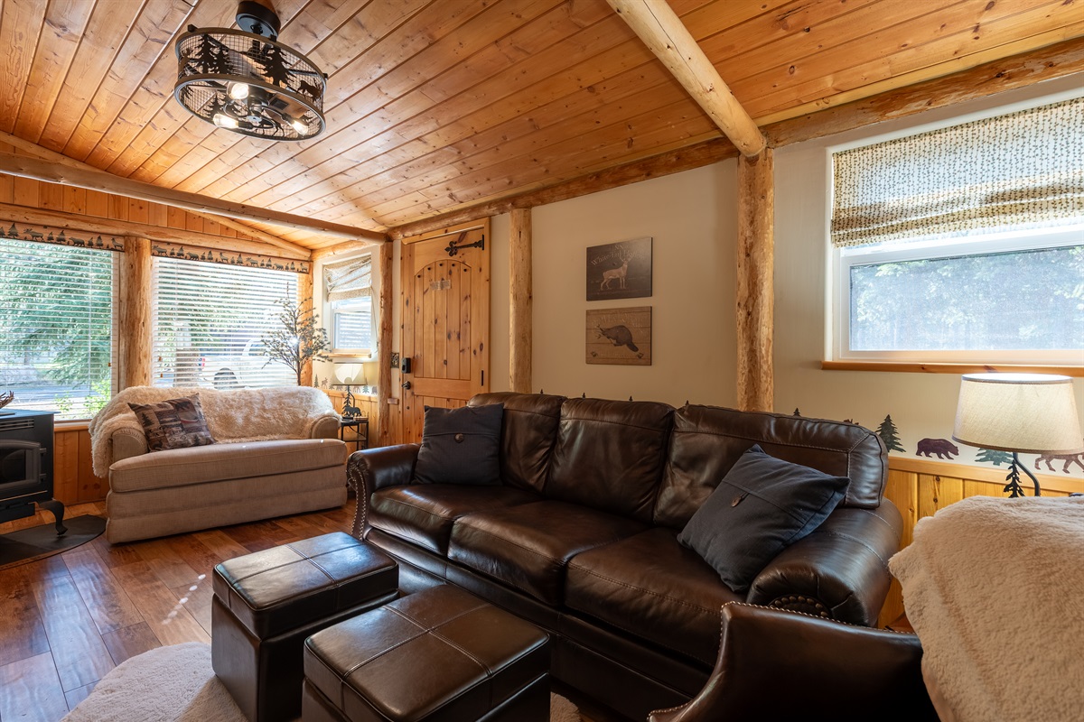 Living room with leather couch, cozy sitting area, and pellet stove