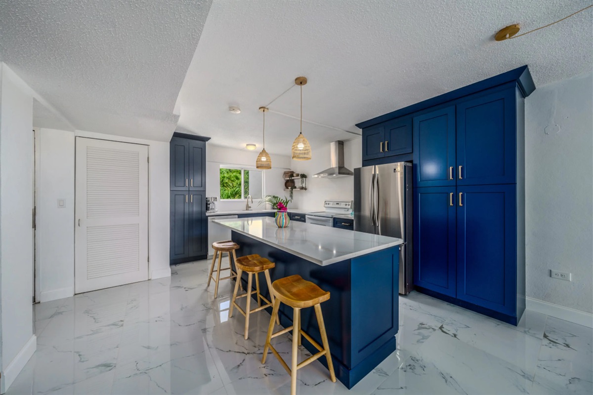 Modern kitchen with island seating&mdash;perfect for casual dining, entertaining, or morning coffee before the beach.