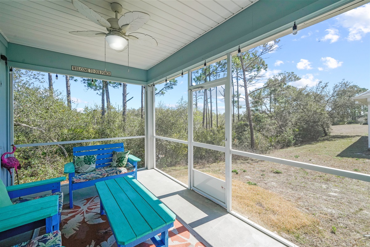 Screened porch with outdoor seating and ceiling fan
