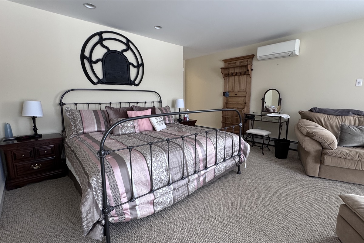 Primary bedroom with private wet bar, large stand-alone soaking tub, and access to private balcony 