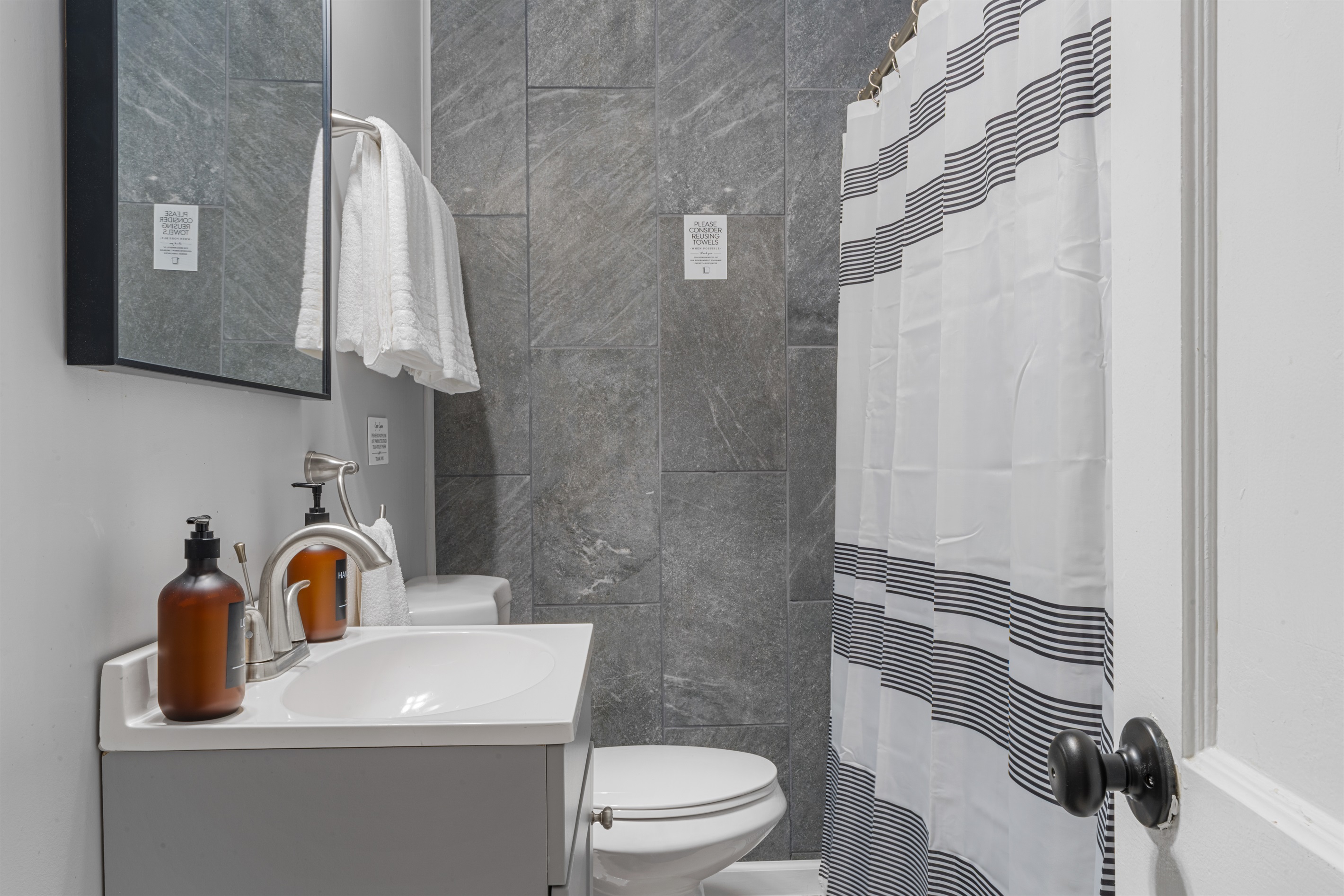 Compact and modern full bathroom with a clean walk-in shower, fresh towels, and complimentary toiletries