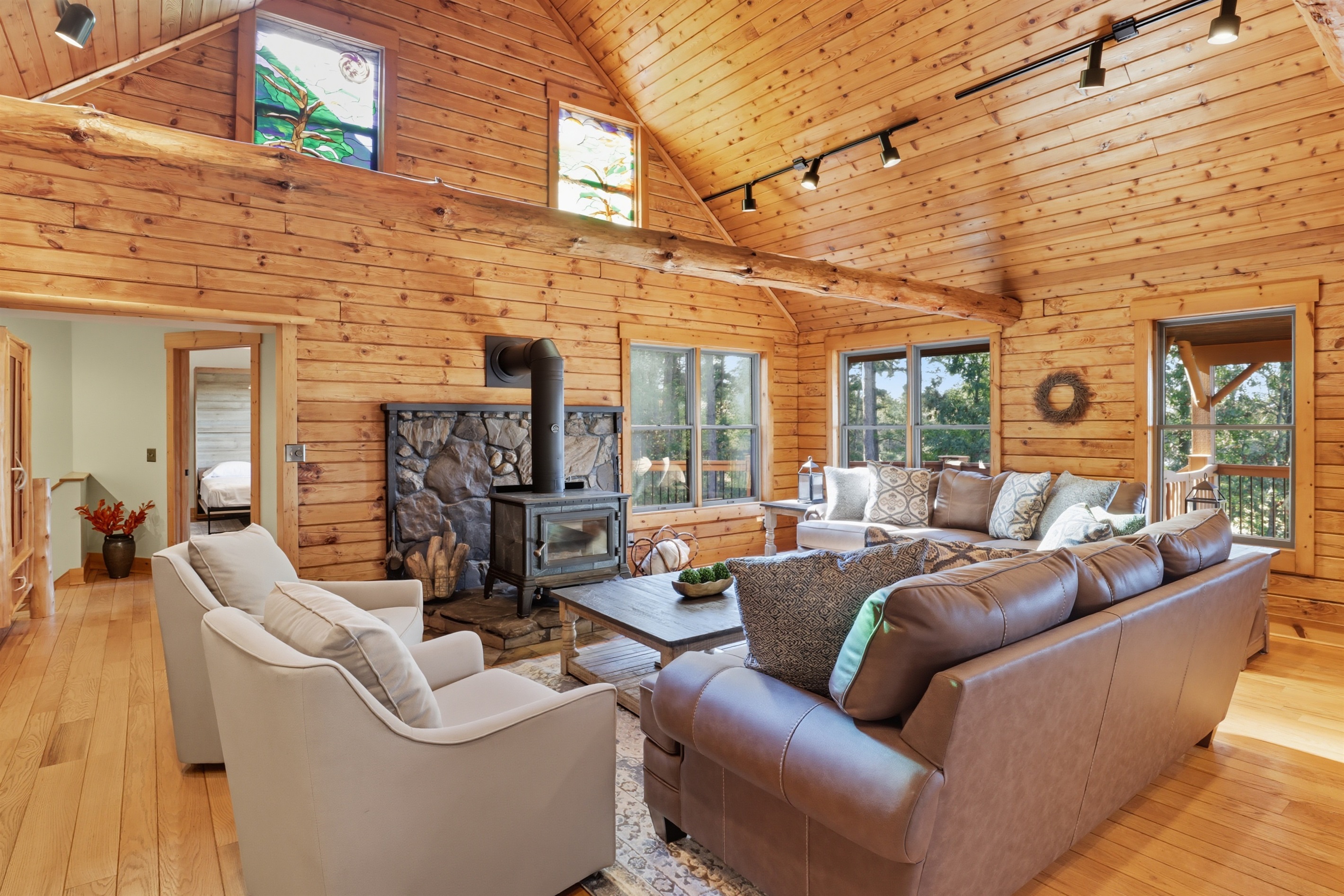 Spacious great room with soaring ceilings, wood beams, and natural light.