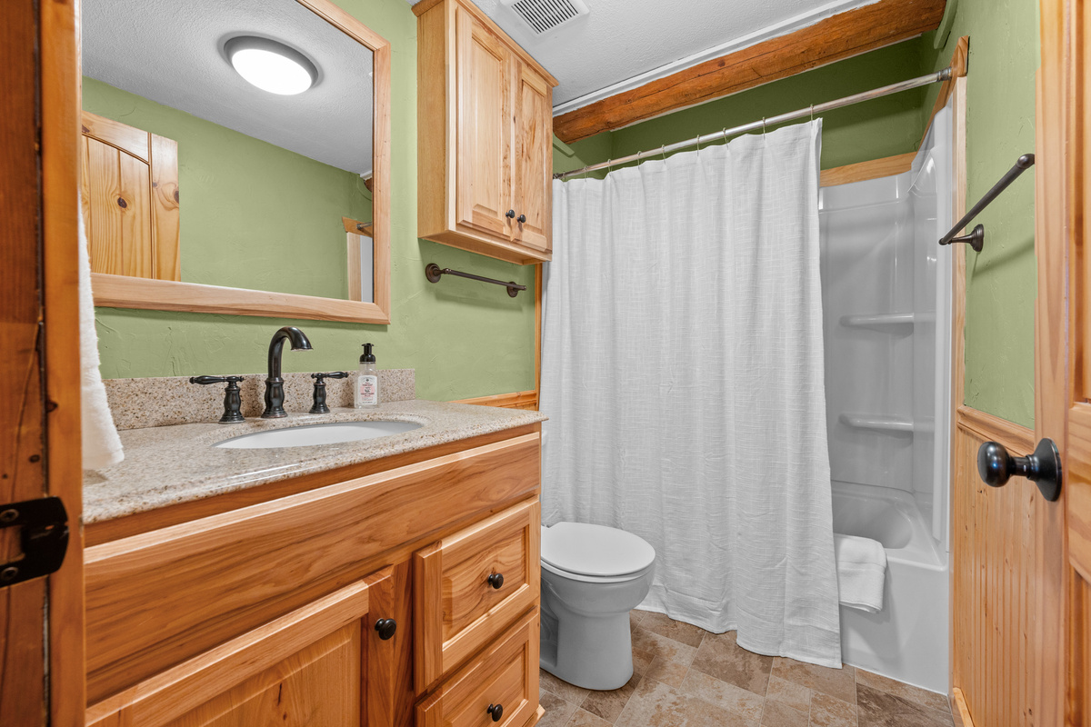 Main-level full bathroom with vanity and convenient tub/shower combination.