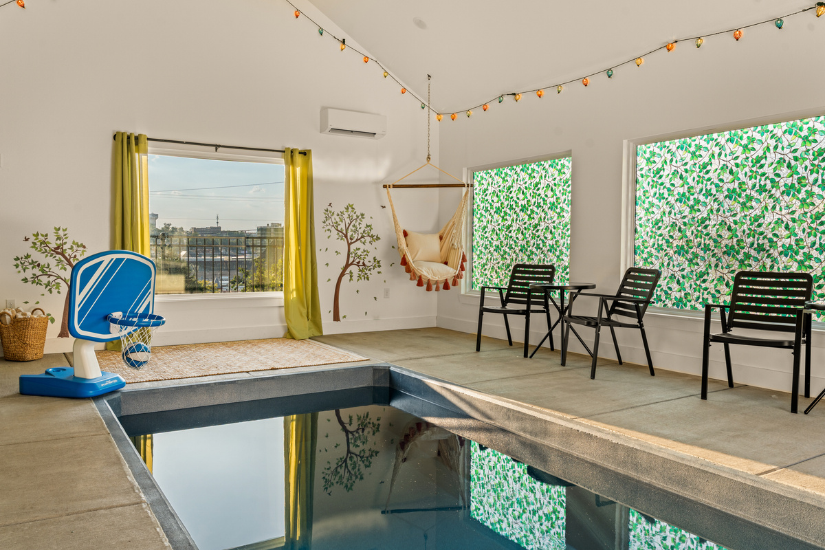 The private pool house features a mini basketball hoop, ample seating, and a window overlooking the Branson landing view.
