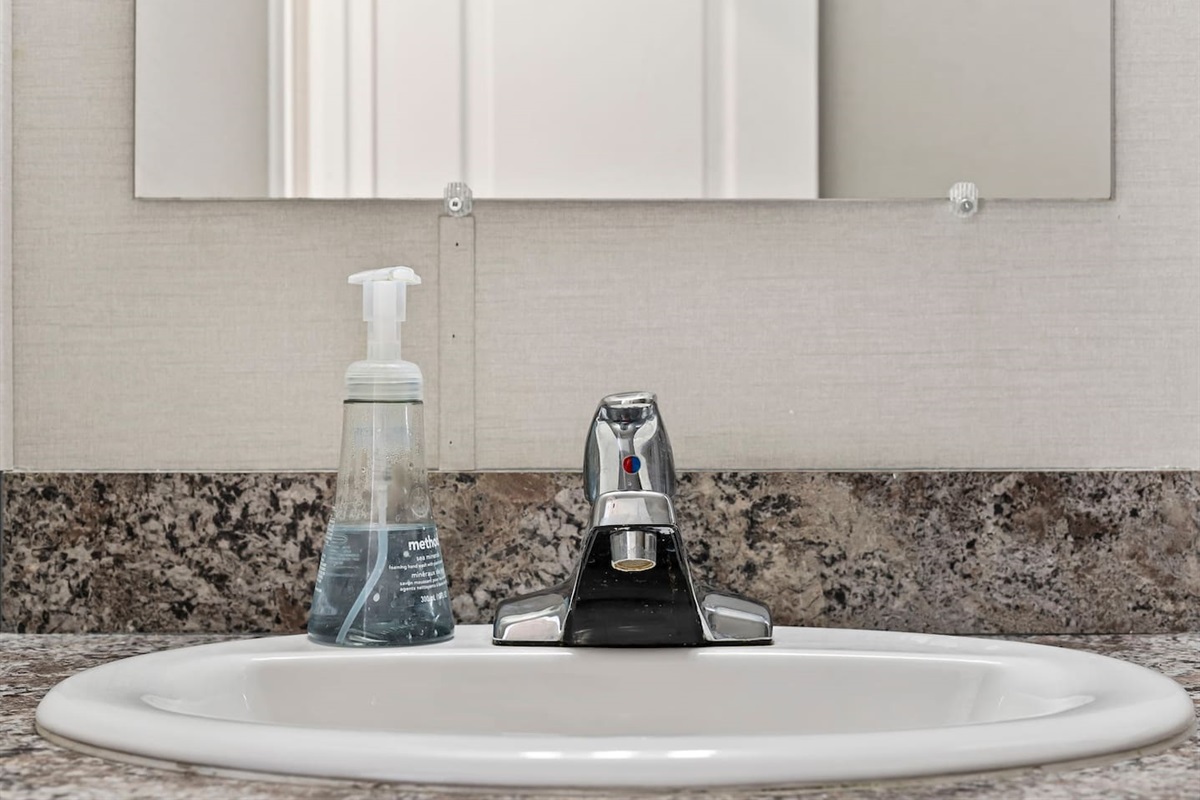 Vanity and sink area with sleek fixtures and convenient counter space for your daily essentials.