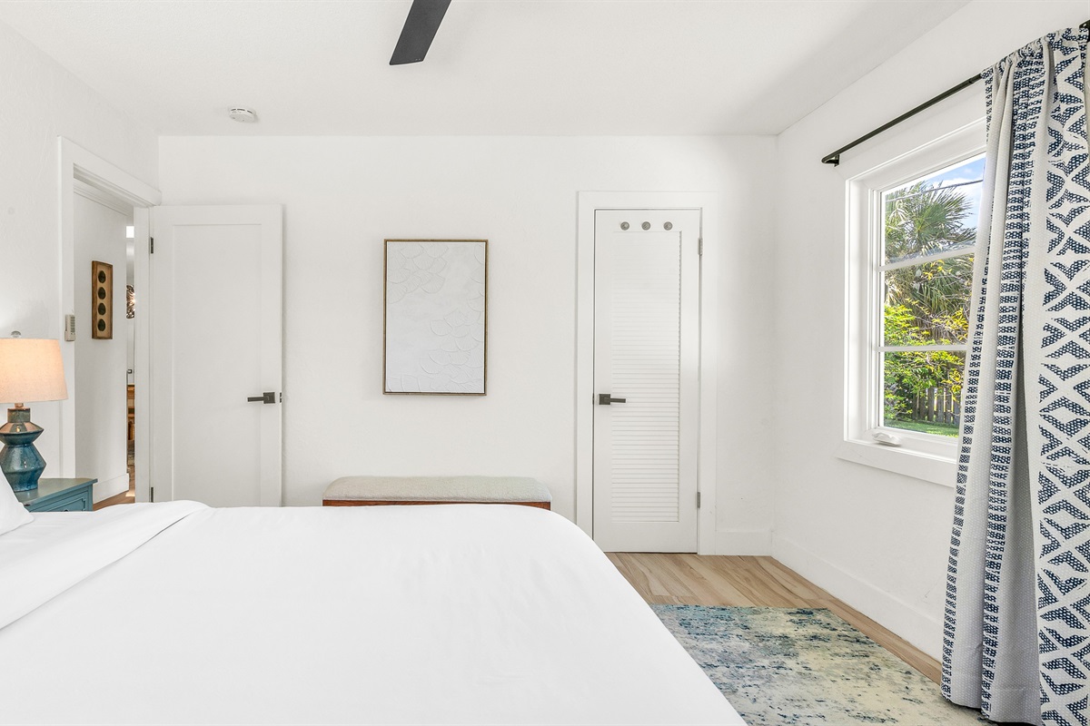 Bedroom 3 features bright coastal decor, crisp white linens, and pops of ocean blue- creating a serene and cheerful retreat for guests to relax and unwind in comfort.