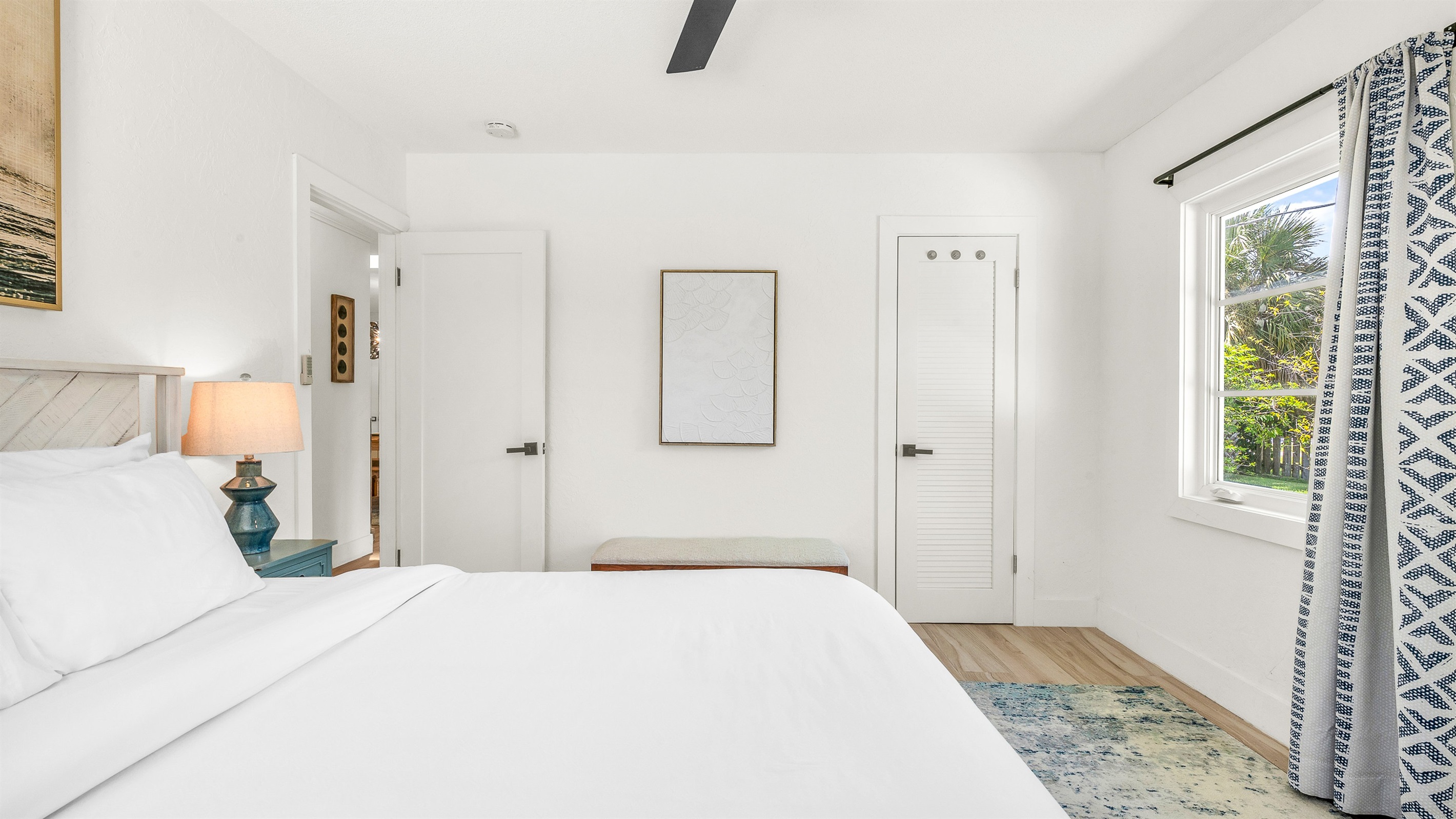 Bedroom 3 features bright coastal decor, crisp white linens, and pops of ocean blue- creating a serene and cheerful retreat for guests to relax and unwind in comfort.
