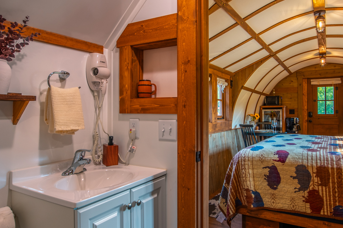 Full private bathroom with vanity, hair dryer, robes, and direct access from the sleeping area.