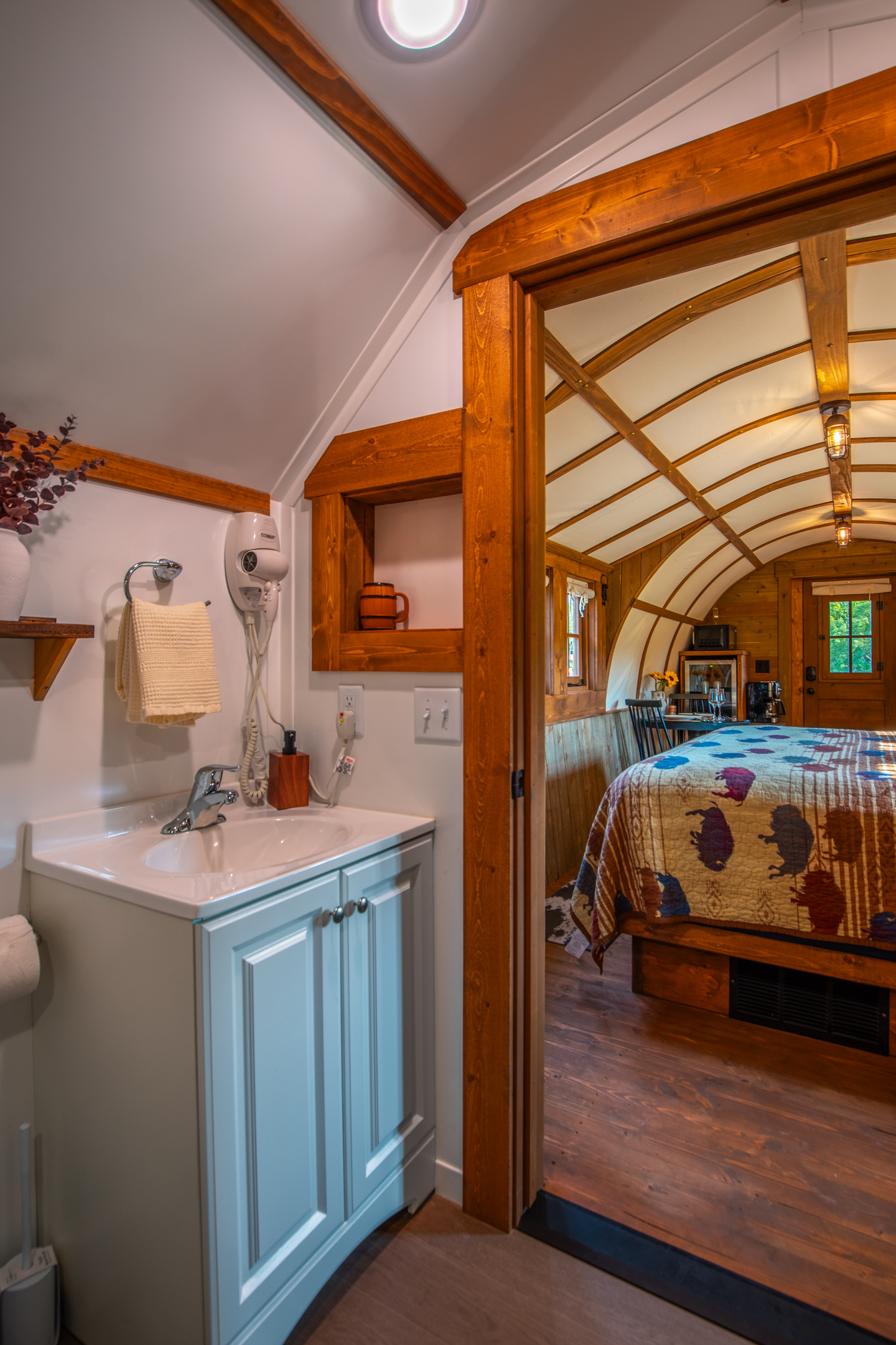 Full private bathroom with vanity, hair dryer, robes, and direct access from the sleeping area.