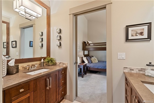 Upstairs Jack and Jill bathroom featuring a double vanity and walk-in shower.