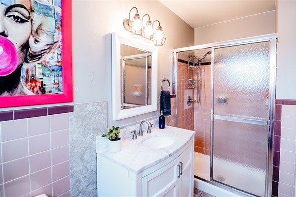 Modern Bathroom Haven: Toilet and Sink Area Enhanced by a Tri-Lighted Mirror, Featuring a Chic Painting with a Pink Frame for Added Flair 🚽💡🖼️