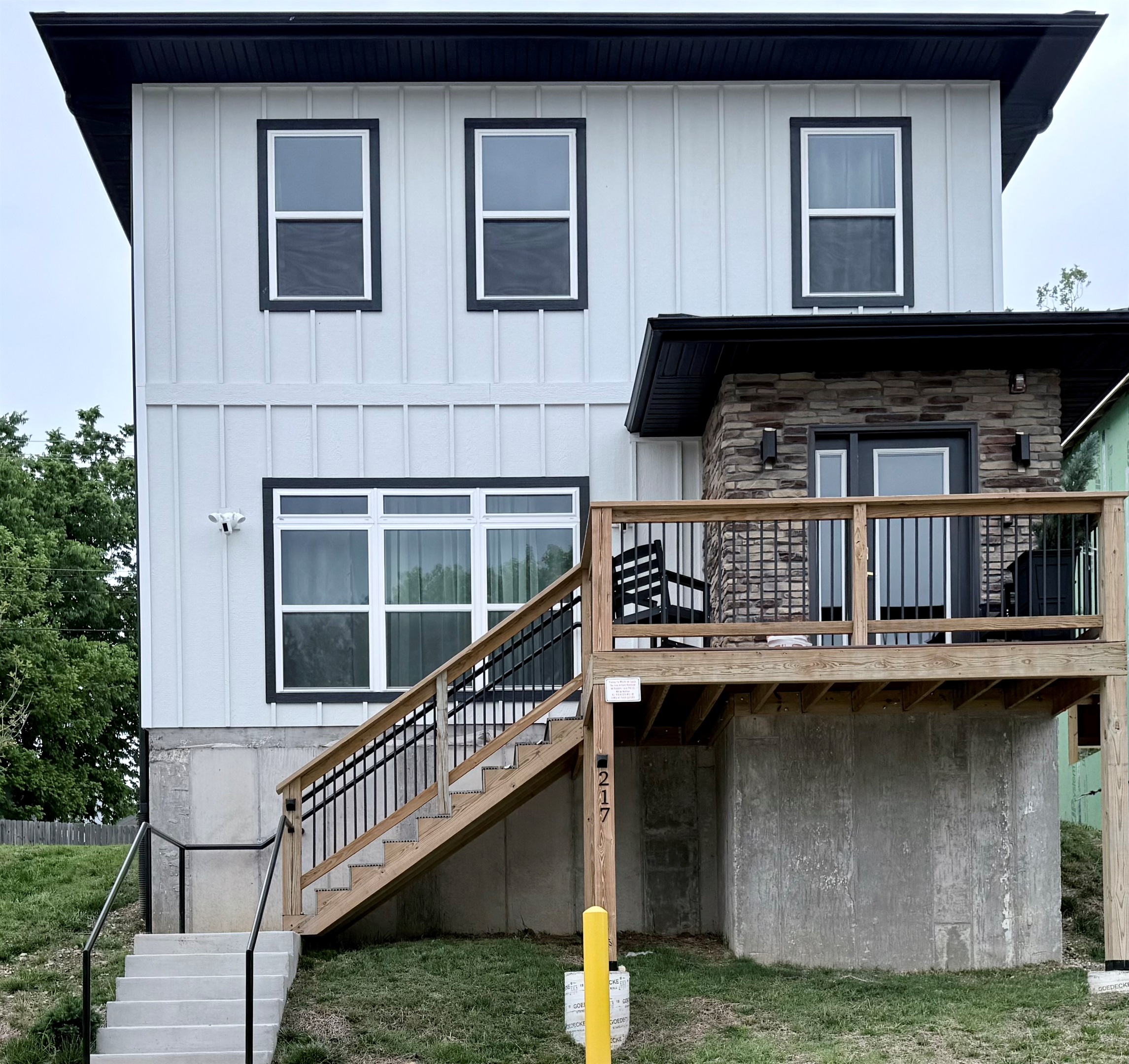 Front elevation of new vacation home with stone exterior at front door. Steps can be avoided by parking in rear parking space. Spacious with nine foot ceilings.