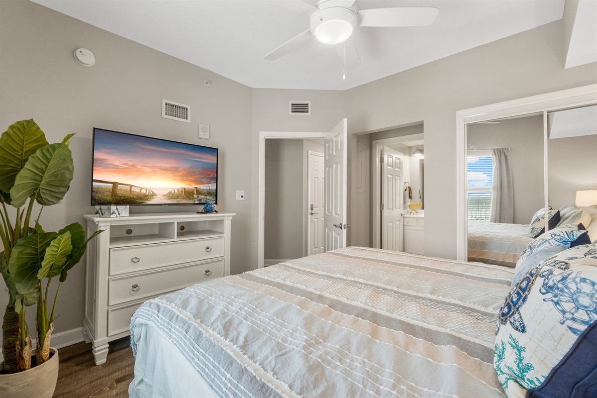 Master bedroom with a king-sized bed, flat-screen smart TV, and a private full bathroom