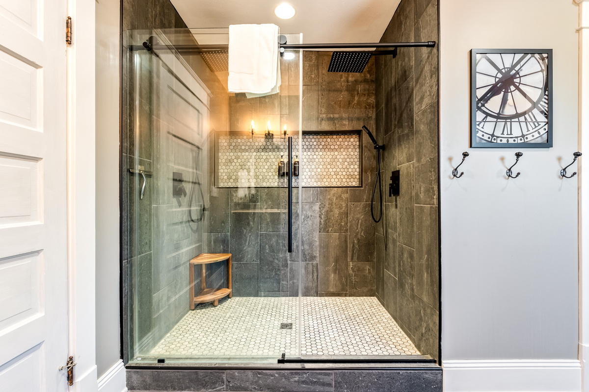 Wash the beach sand away in style. The custom ensuite bathroom features a stunning walk-in shower with floor-to-ceiling tile, seamless glass, and a luxury rainwater showerheads